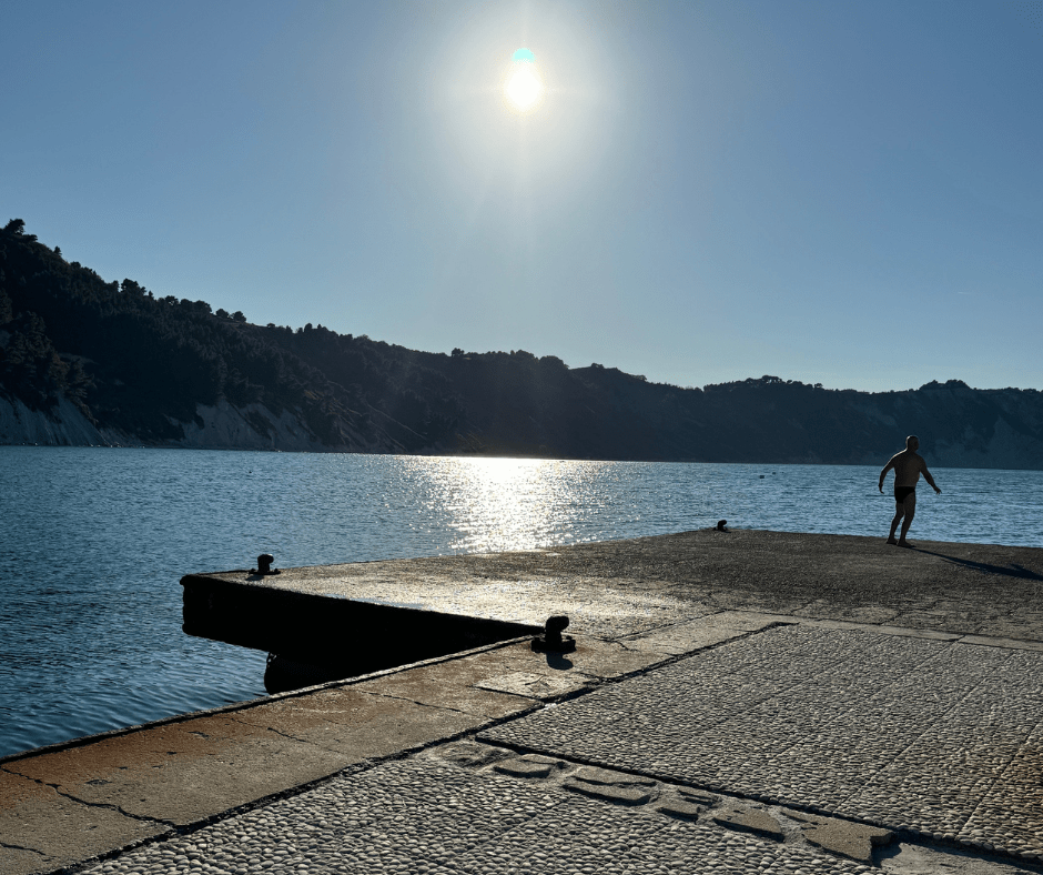 strand met blauwe heldere zee. bergen op de achtergrond