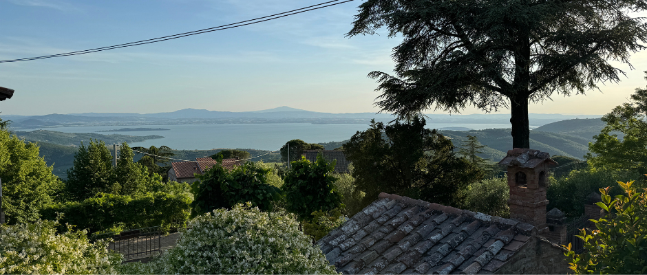 Uitzicht vanaf een berg naar het trasimenomeer kijkend over huisjes